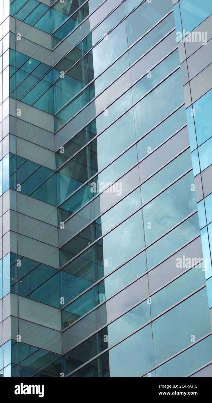 Bâtiment moderne avec fenêtres en verre reflétant le ciel. Arrière-plan au format vertical Banque D'Images