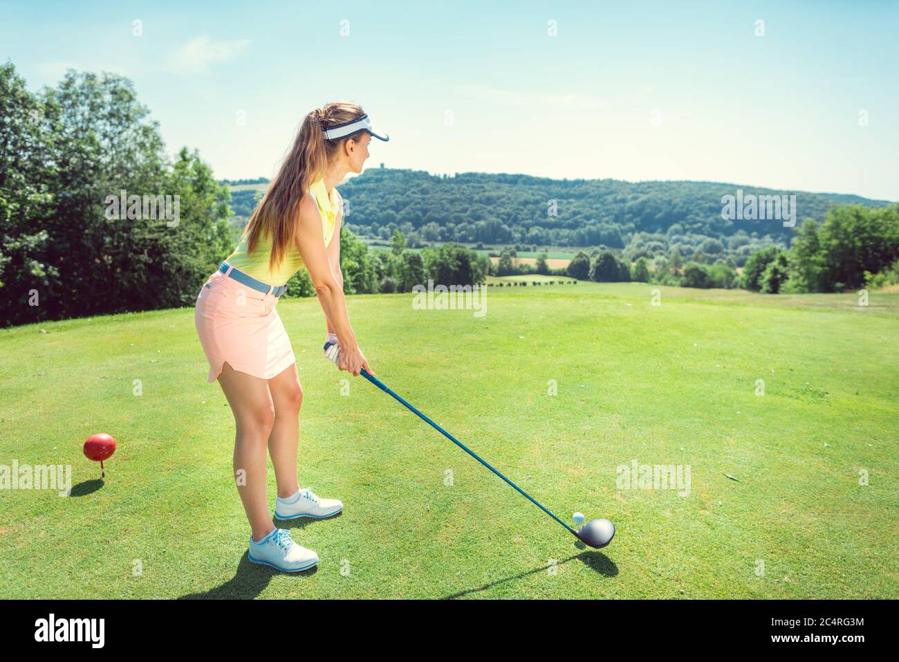 Belle femme jouant au golf sur un terrain ouvert Banque D'Images