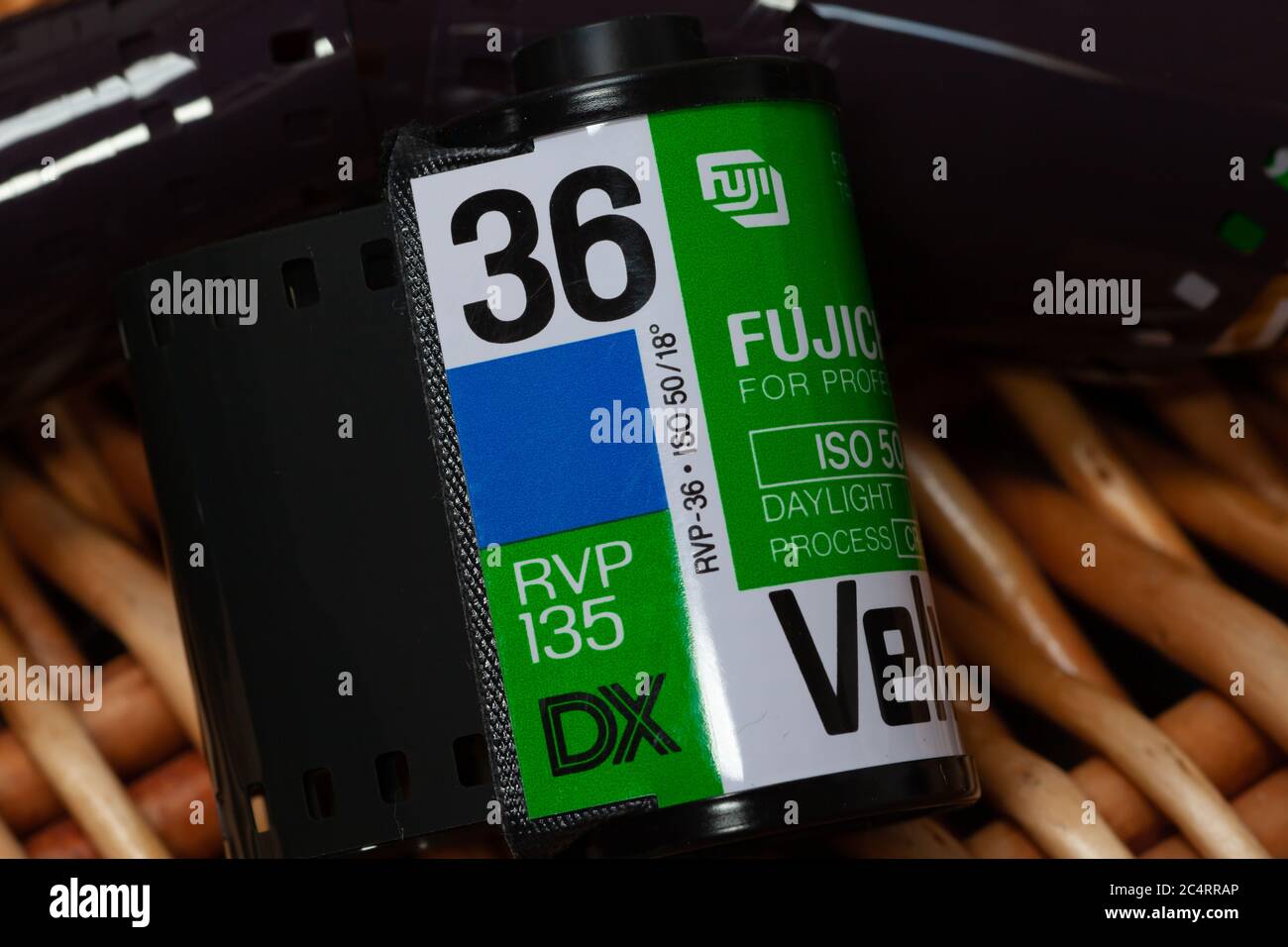 Rouleau de film transparent couleur Fujichrome Velvia 35 mm sur fond de panier en osier. Banque D'Images