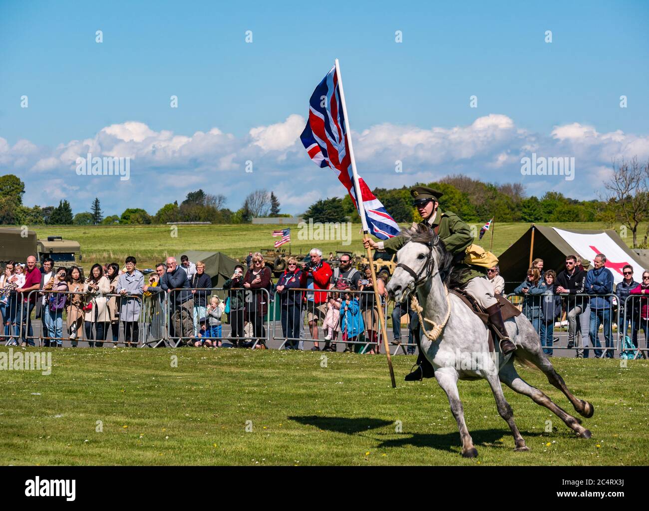 Les amis d'Onno équipe de cascades équestres avec un soldat à cheval portant un grand drapeau de l'Union Jack, événement de guerre, Fortune est, Lothian est, Écosse Banque D'Images