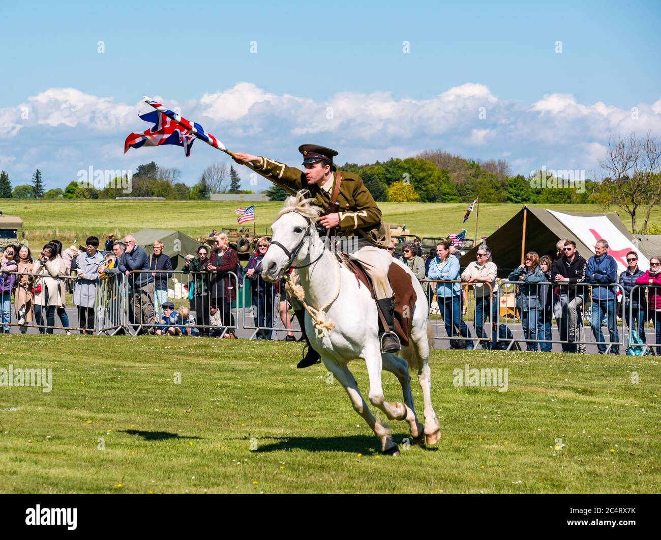 L'équipe de cascades équestres les amis d'Onno avec un soldat qui charge à cheval avec Union Jack à l'événement de guerre, East Fortune, East Lothian, Écosse, Royaume-Uni Banque D'Images