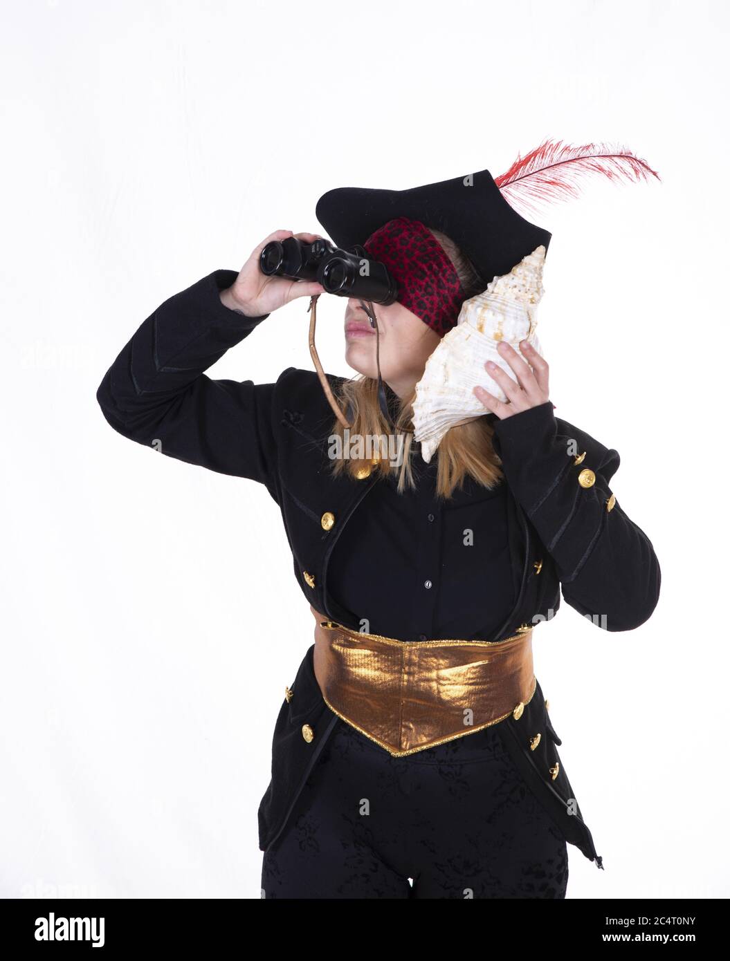 Une femme en costume de pirate regardant avec des jumelles et tenant une  grosse coque près de son oreille Photo Stock - Alamy