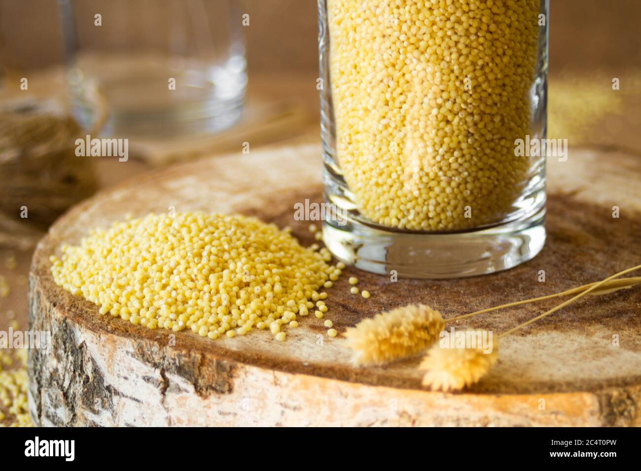 Millet dans un pot de verre sur un stand en bois, puis est une oreille de blé Banque D'Images
