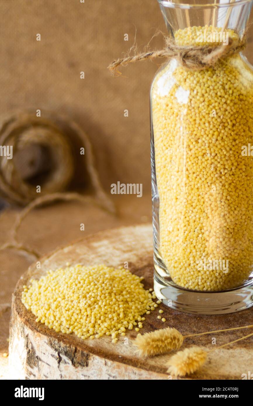 Millet dans un pot de verre sur un stand en bois, puis est une oreille de blé Banque D'Images
