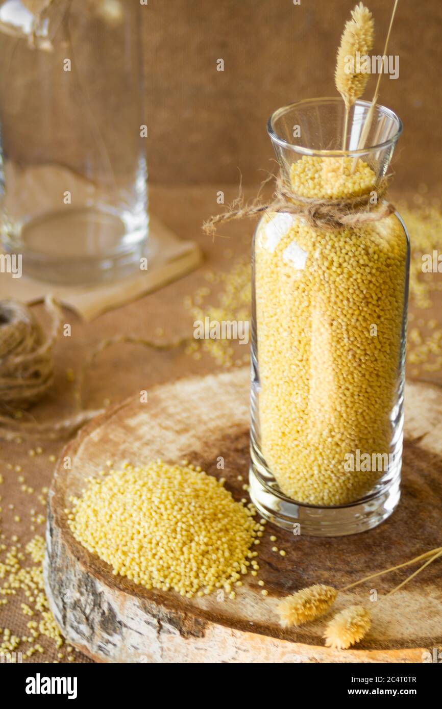 Millet dans un pot de verre sur un stand en bois, puis est une oreille de blé Banque D'Images