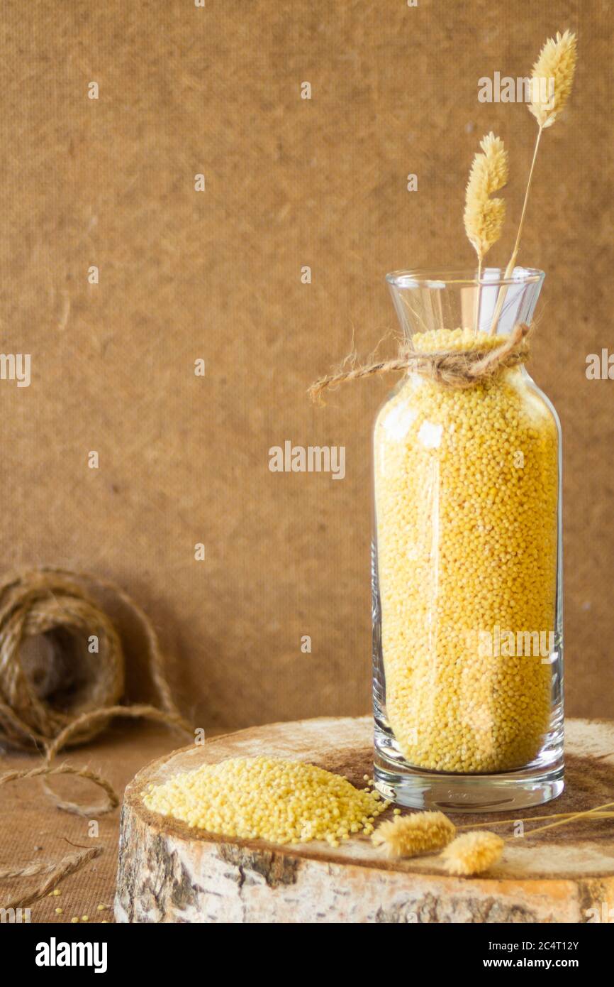 Millet dans un pot de verre sur un stand en bois, puis est une oreille de blé Banque D'Images