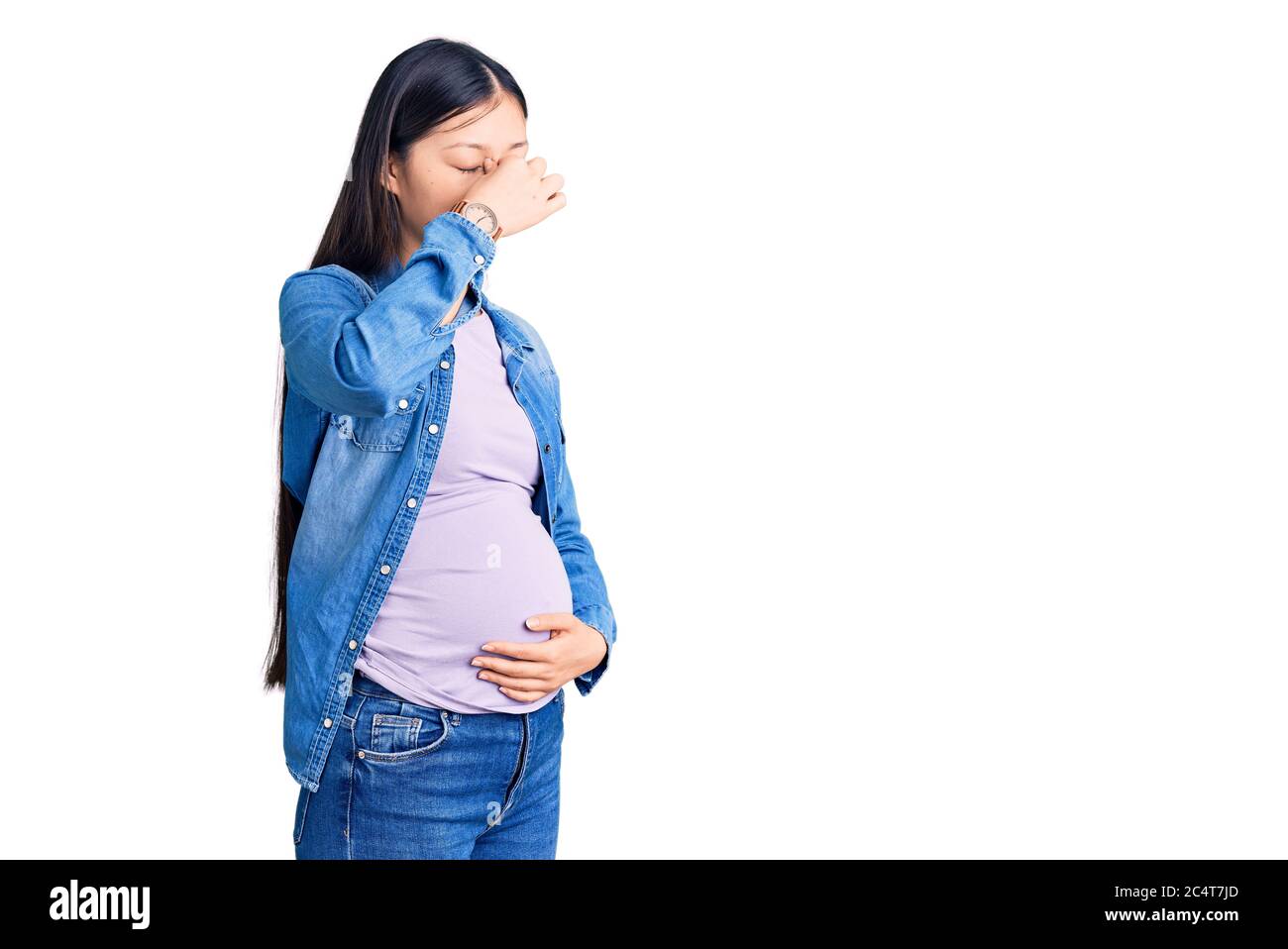 Jeune belle femme chinoise enceinte s'attendant bébé fatigué se frottant nez et yeux sensation de fatigue et de maux de tête. Concept de stress et de frustration. Banque D'Images
