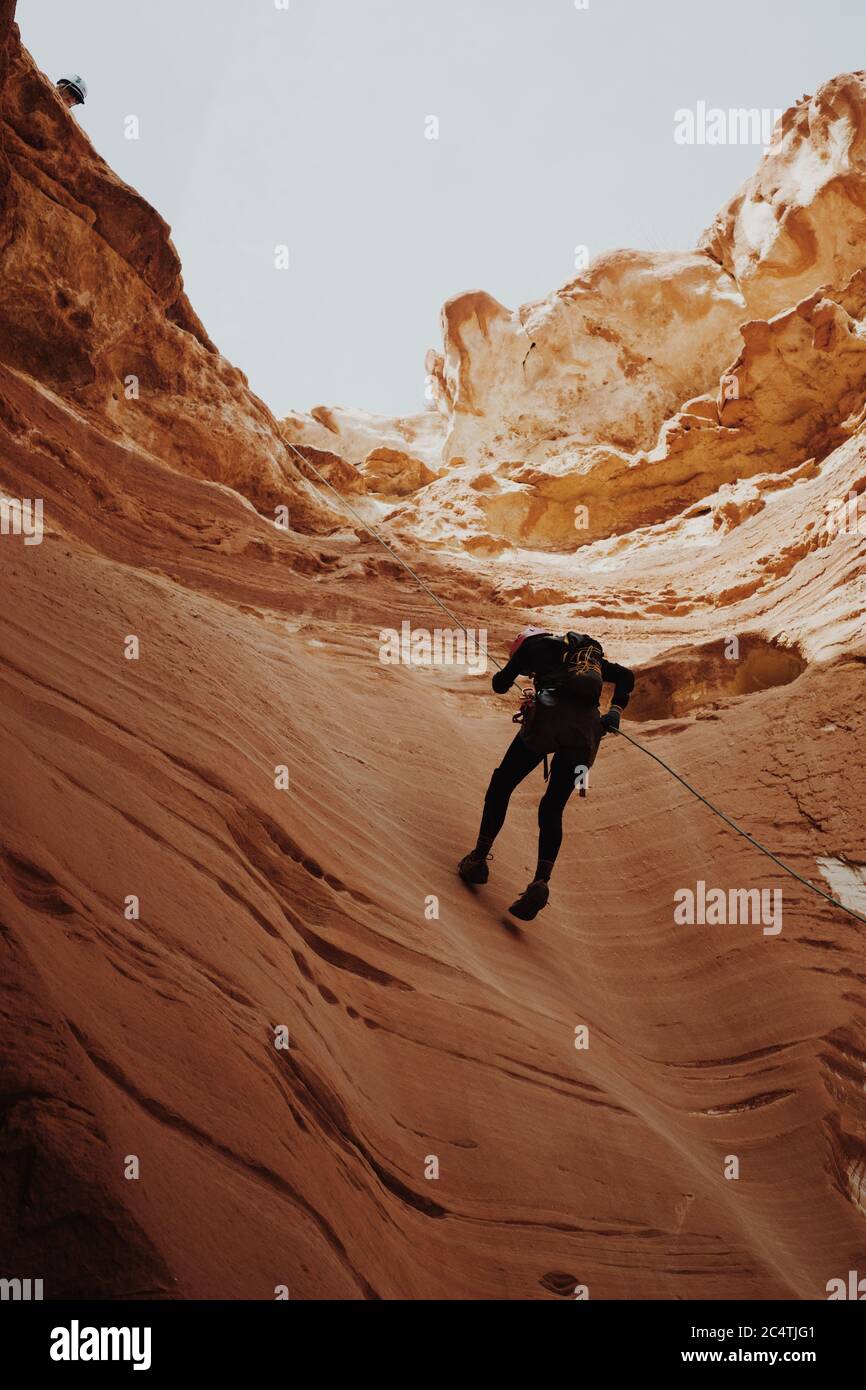 Homme essayant de grimper sur les falaises du canyon Banque D'Images