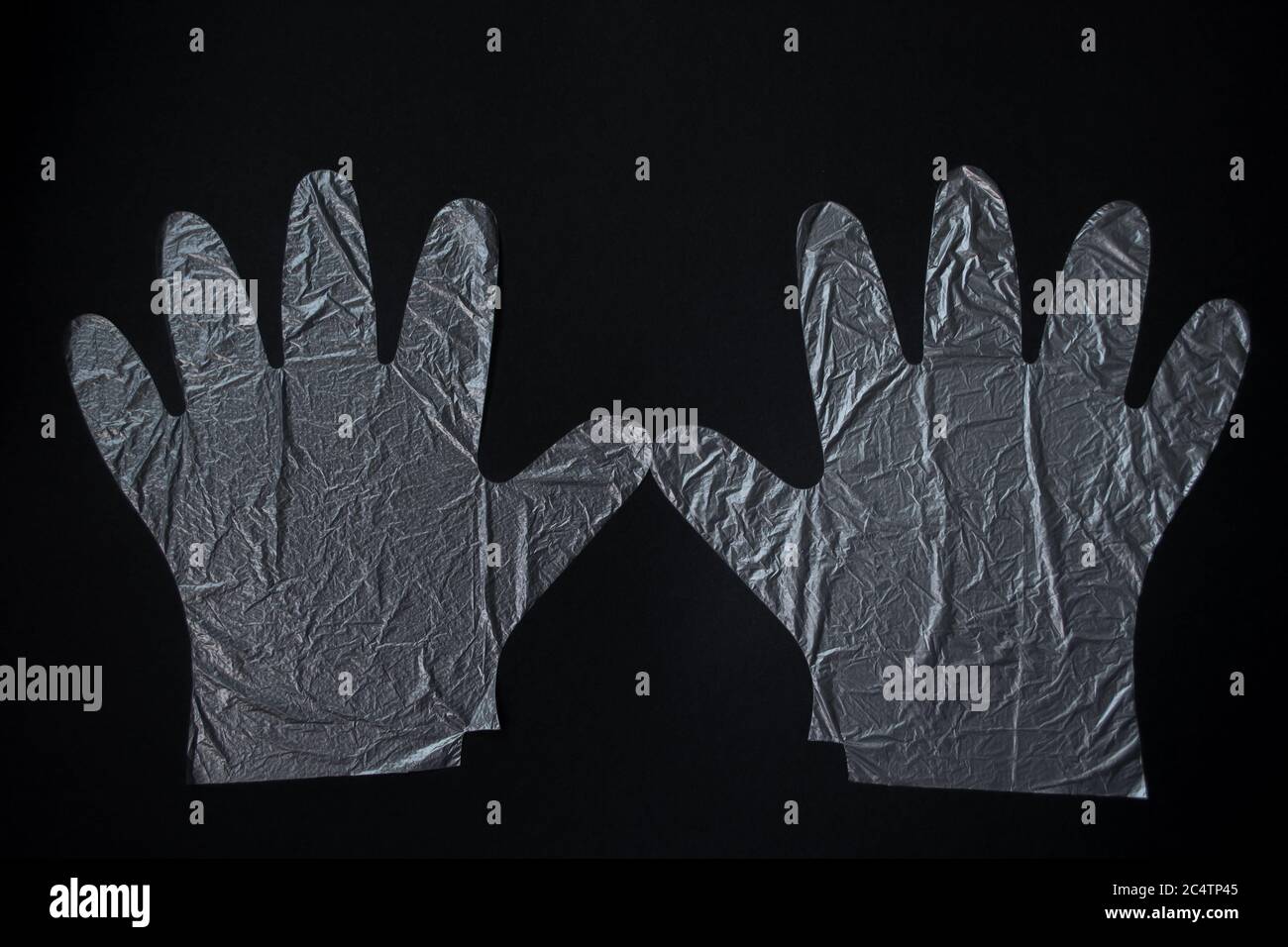 Une paire de gants en plastique jetables sur fond noir. Concept de protection. Banque D'Images