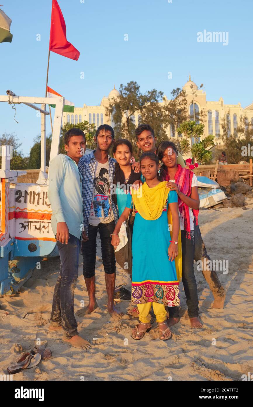 Des adolescents indiens ou des jeunes du millénaire posant à Chowpatty Beach, Mumbai, Inde, un endroit populaire pour profiter du plein air; b/g: Le palais-comme l'hôpital Saifi Banque D'Images