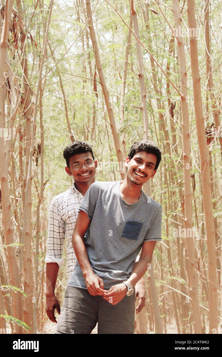 Portrait de deux amis souriant à l'appareil photo, sur l'arrière-plan comme des arbres de portrait, forêt. Banque D'Images
