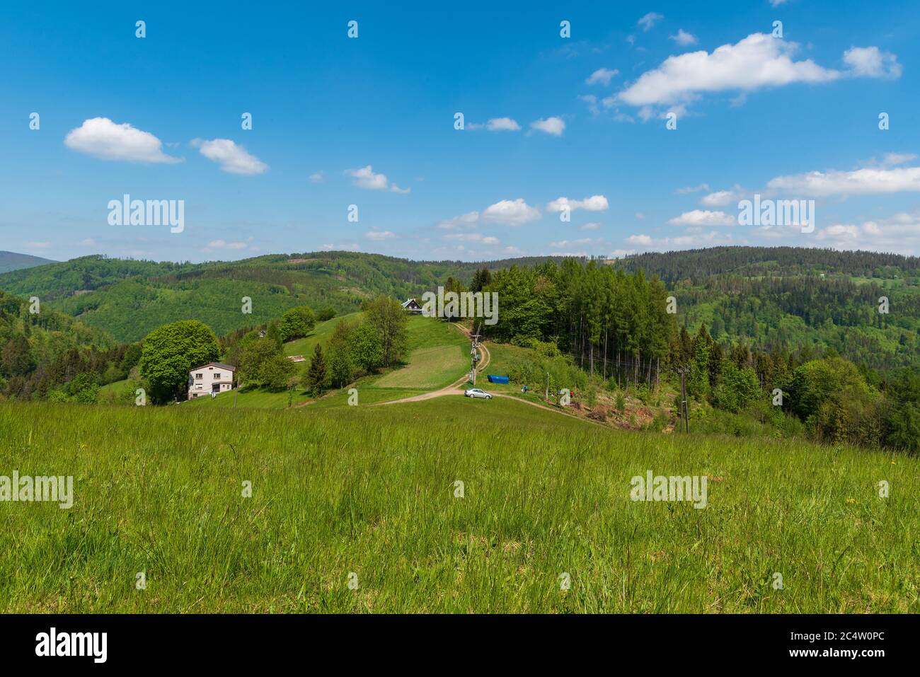 Les montagnes de Slezske Beskydy, très belles, près de la colline de Filipka en République tchèque avec des prés, peu de maisons isolées, des routes de terre et des collines en arrière-plan Banque D'Images