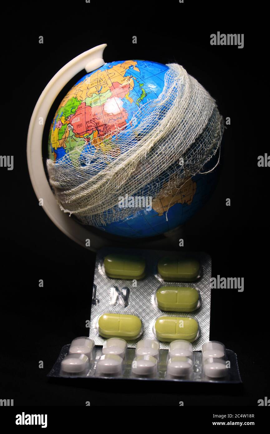Le globe et les pilules sur fond noir. Métaphore de la pandémie mondiale du virus corona. Banque D'Images