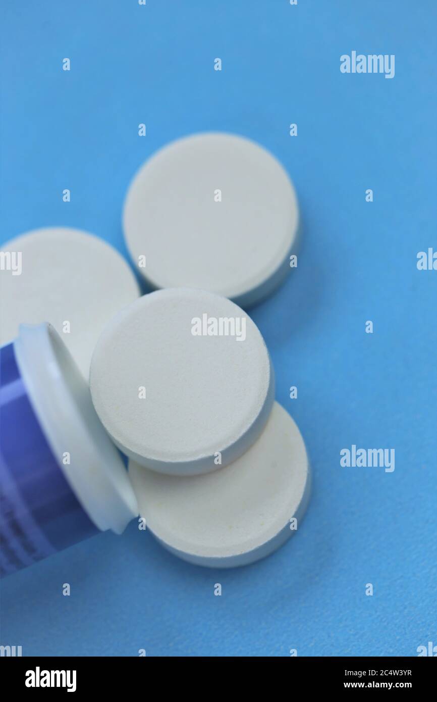 Pilules blanches .rhume et grippe.traitement et prévention des maladies virales. Round White Pills gros-up sur un fond bleu.Medicine and Health concept.Medi Banque D'Images