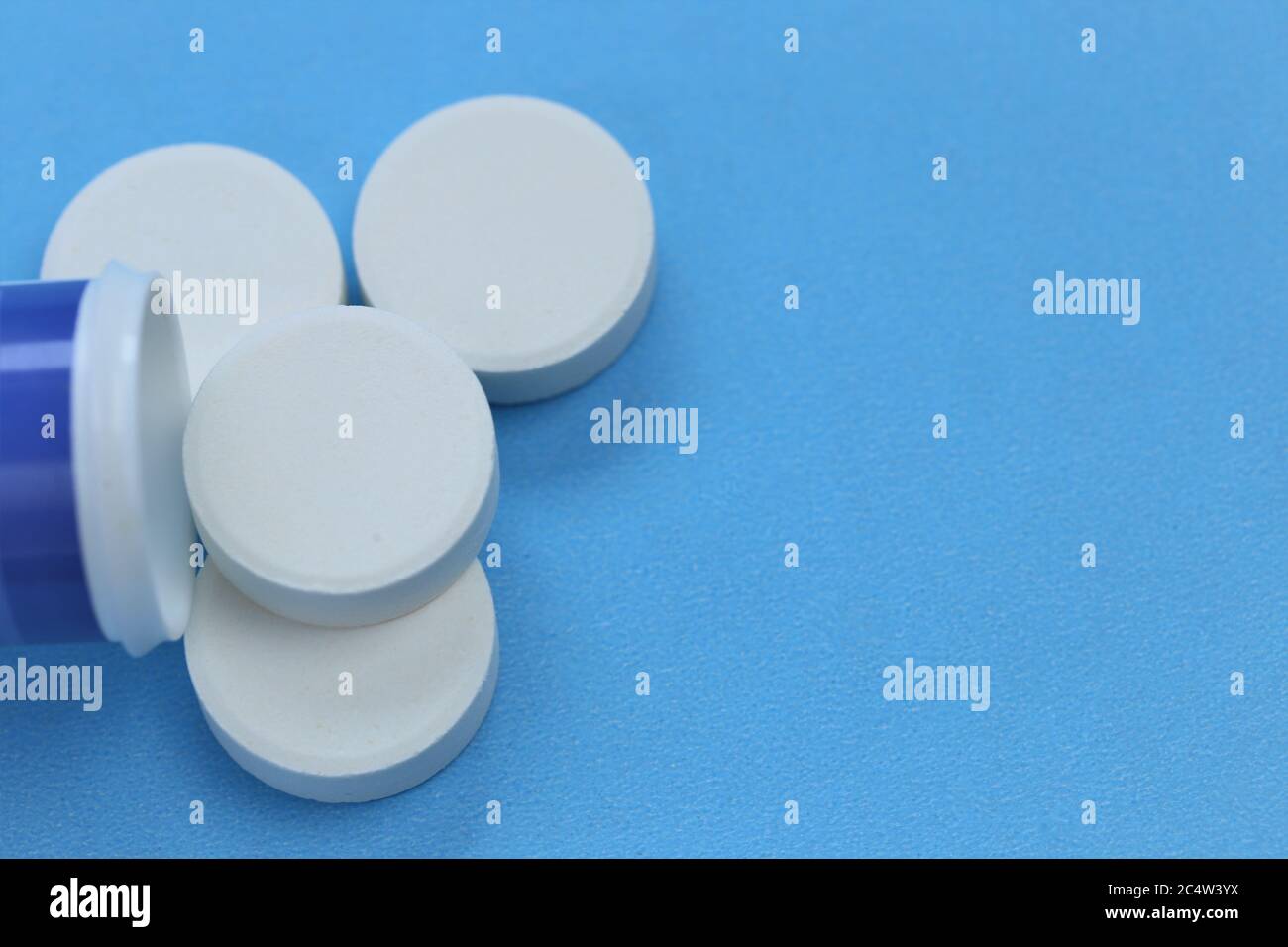 Les pilules blanches en gros.rhume et grippe.traitement et prévention des maladies virales. Ronds pilules blanches gros plan sur un fond bleu.Medicine et santé conc Banque D'Images