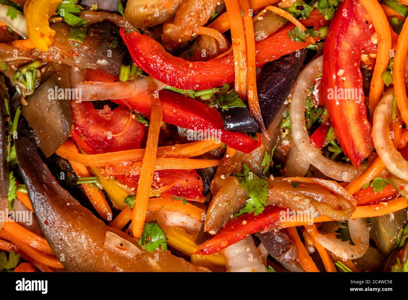 Vue de dessus sur la salade de légumes d'aubergines, carottes, oignons, poivrons aux épices orientales gros plan Banque D'Images