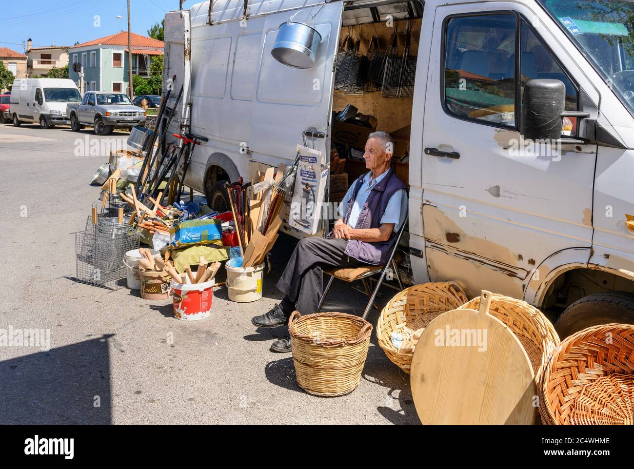 Homme vendant des paniers et des produits d'ironmongers au marché du dimanche dans la petite ville de Kopanaki, au nord-ouest de Messinia, Péloponnèse, Grèce. Banque D'Images