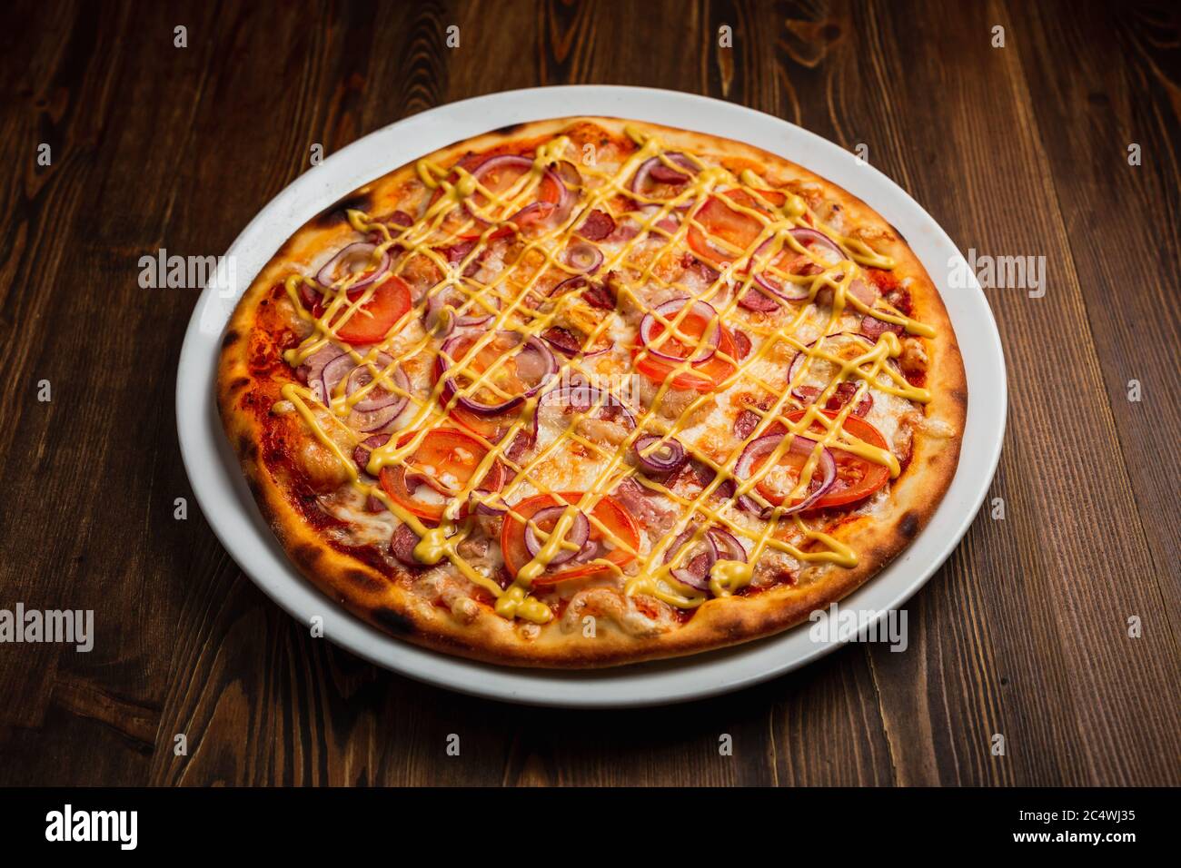 Bacon, saucisse, oignon, pizza nourrissante à la tomate avec sauce au fromage, fond en bois, touche basse Banque D'Images