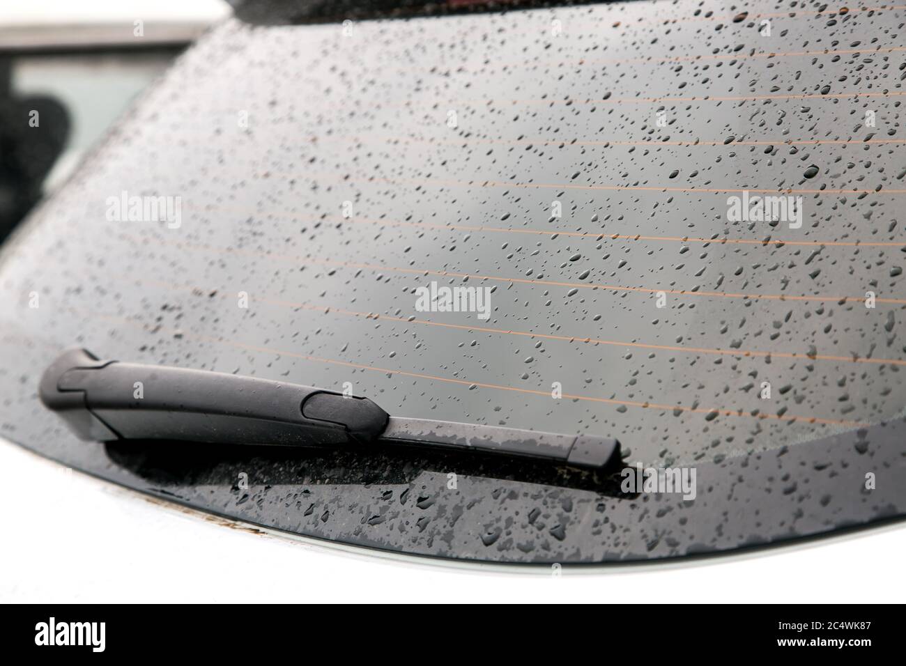 La lunette arrière de la voiture est recouverte de gouttes d'eau après la  pluie, la lunette arrière chauffante et l'essuie-glace Photo Stock - Alamy