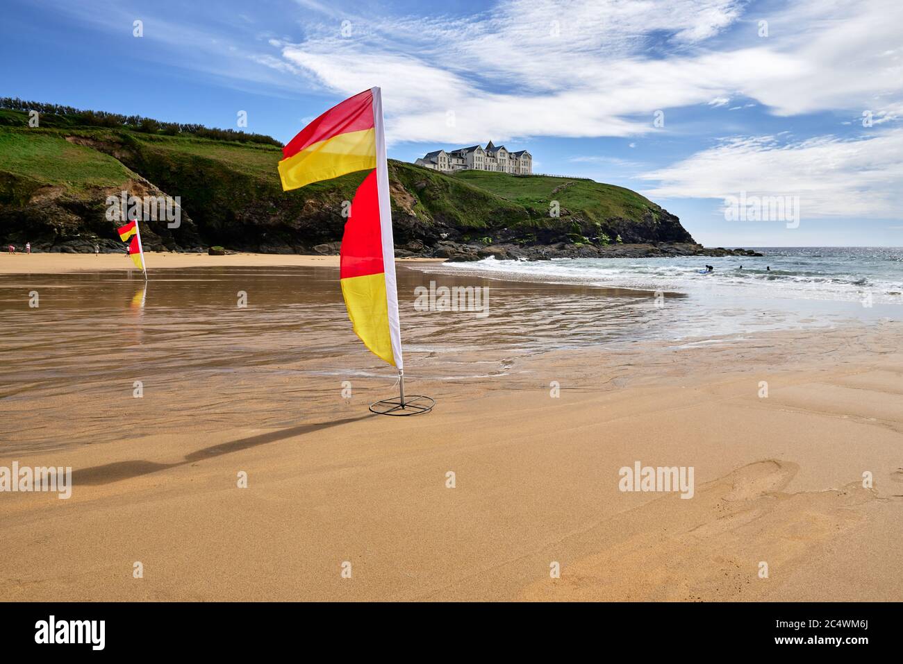 Drapeaux de sauveteurs marquant la zone de baignade sécuritaire à Poldhu Cove, péninsule de Lizard, Cornwall, Royaume-Uni Banque D'Images