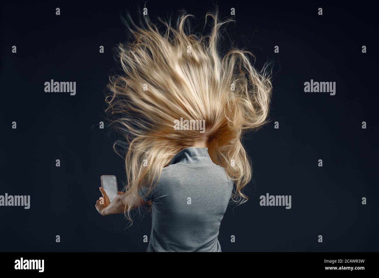 Femme debout contre un flux d'air puissant, vue arrière Banque D'Images