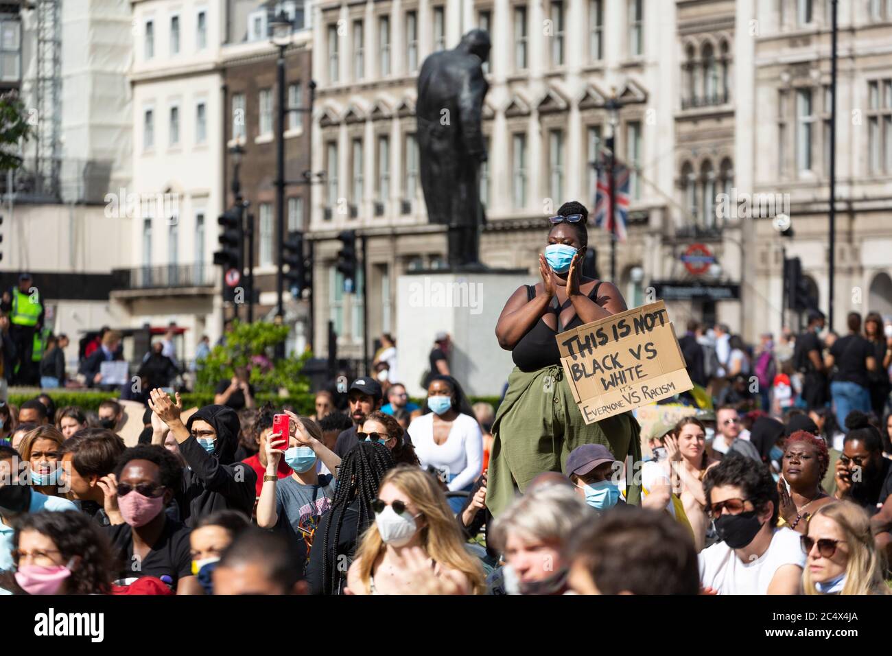 Une manifestante féminine se tient parmi une foule qui applaudit lors d'une démonstration de Black Lives Matter, Parliament Square, Londres, 21 juin 2020 Banque D'Images