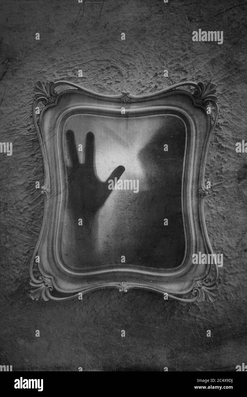Concept d'horreur d'une figure fantôme piégée dans un miroir. Avec un  montage noir et blanc, flou, texturé et flou Photo Stock - Alamy
