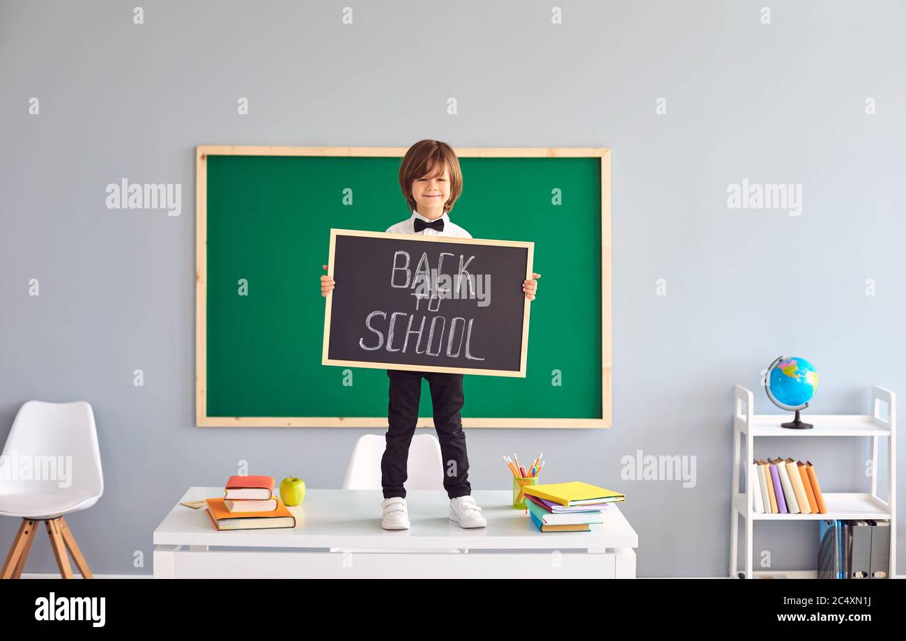 Retour à l'école. Un écolier tient un tableau noir entre ses mains. Banque D'Images