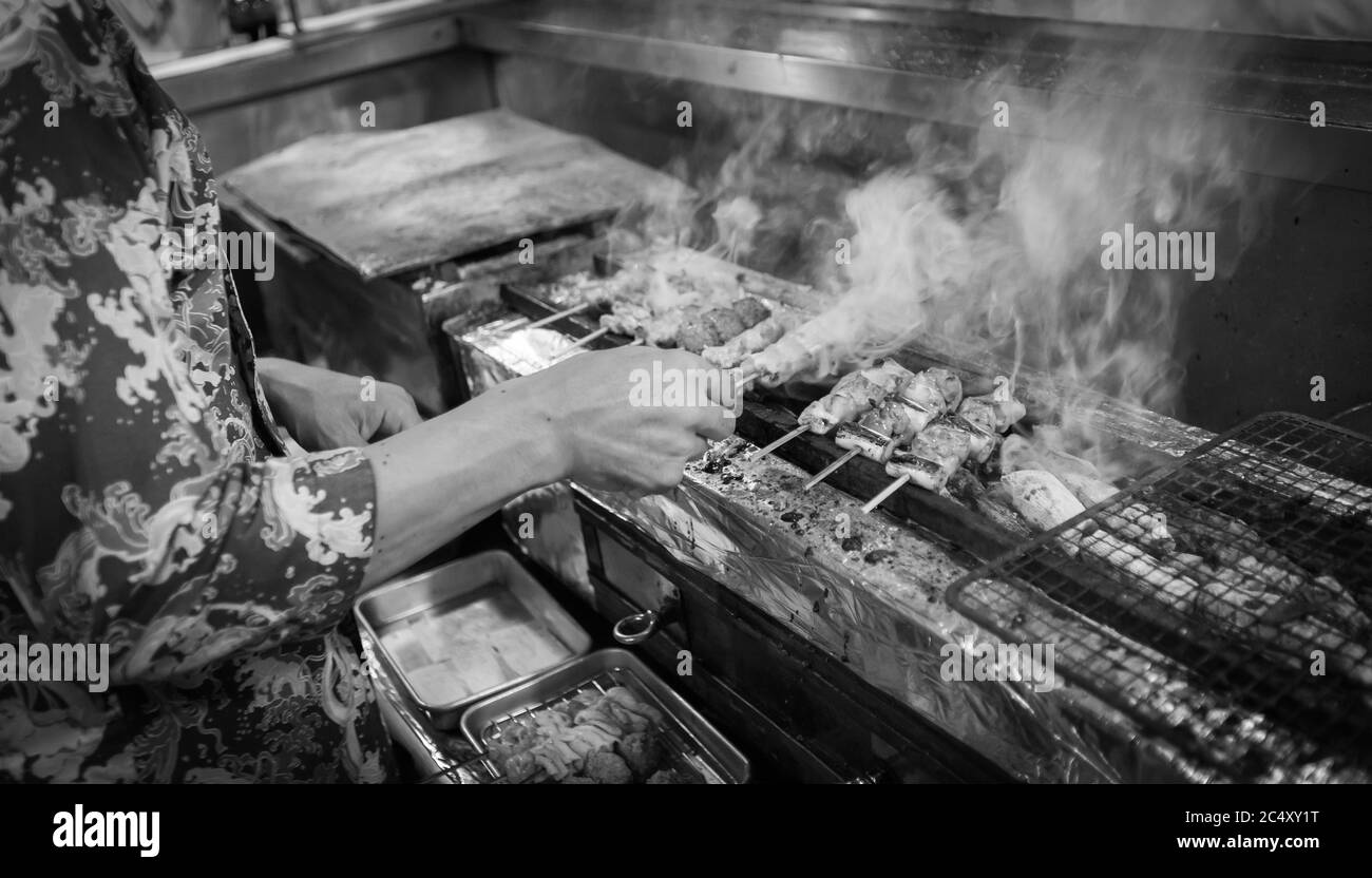 Dans un restaurant yakatori à Tokyo, au Japon, un chef anonyme prépare de délicieux plats barbecue Banque D'Images