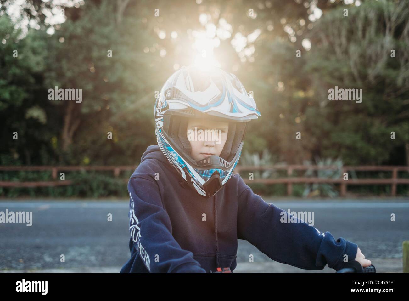 Jeune garçon portant un casque de moto regardant la caméra Banque D'Images