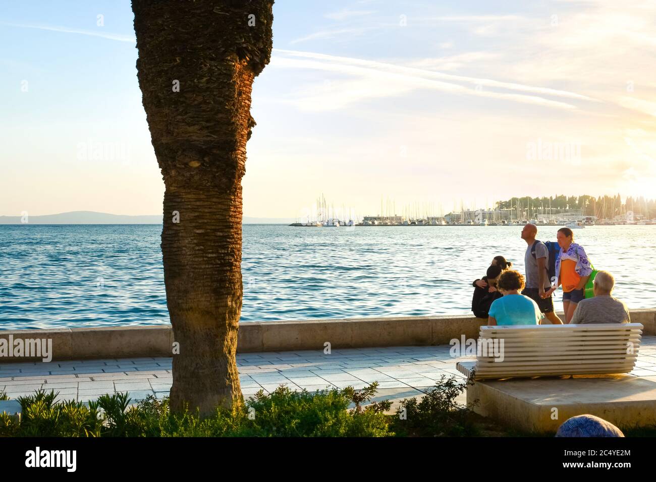 Les touristes apprécient une promenade au coucher du soleil le long du front de mer de Riva Promenade dans l'ancienne ville de Split, Croatie, sur la côte de la Dalmation. Banque D'Images