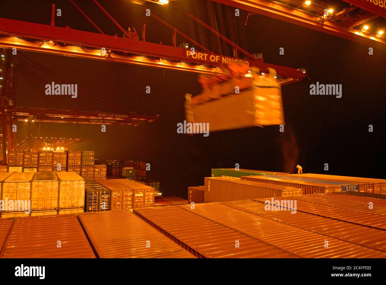 port de ningbo, chine - 12 janvier 2007 : le containership allemand jamais conquérir (9293818) décharger des conteneurs pendant les fortes pluies la nuit - Banque D'Images