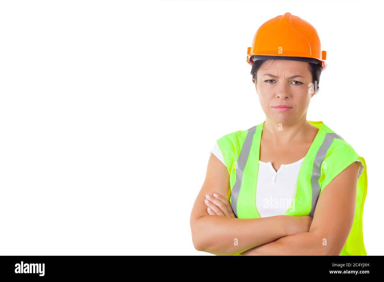 Femme sérieuse attirante travailleuse dans la veste de sécurité et casque jaune sur fond blanc Banque D'Images
