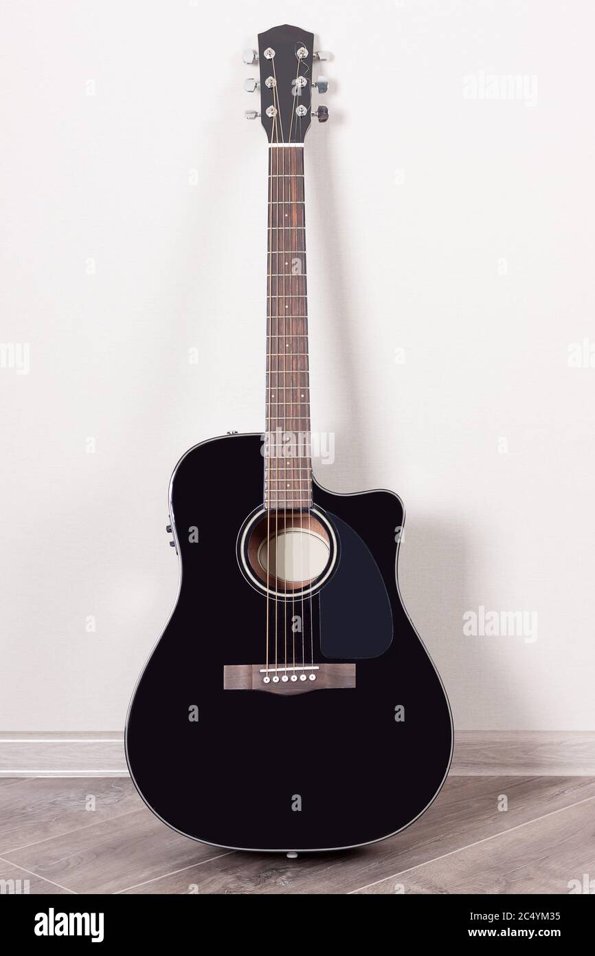 Guitare acoustique classique noire dans une pièce vide très gros plan Banque D'Images