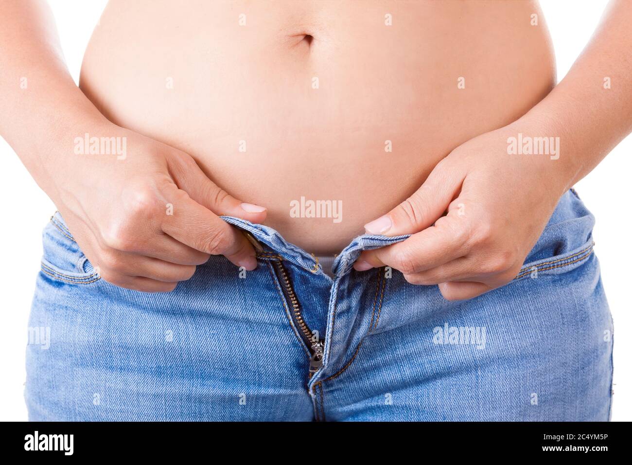 Concept de régime. Les mains des femmes ne peuvent pas fermer les jeans en raison de la prise de graisse sur les hanches très gros plan Banque D'Images
