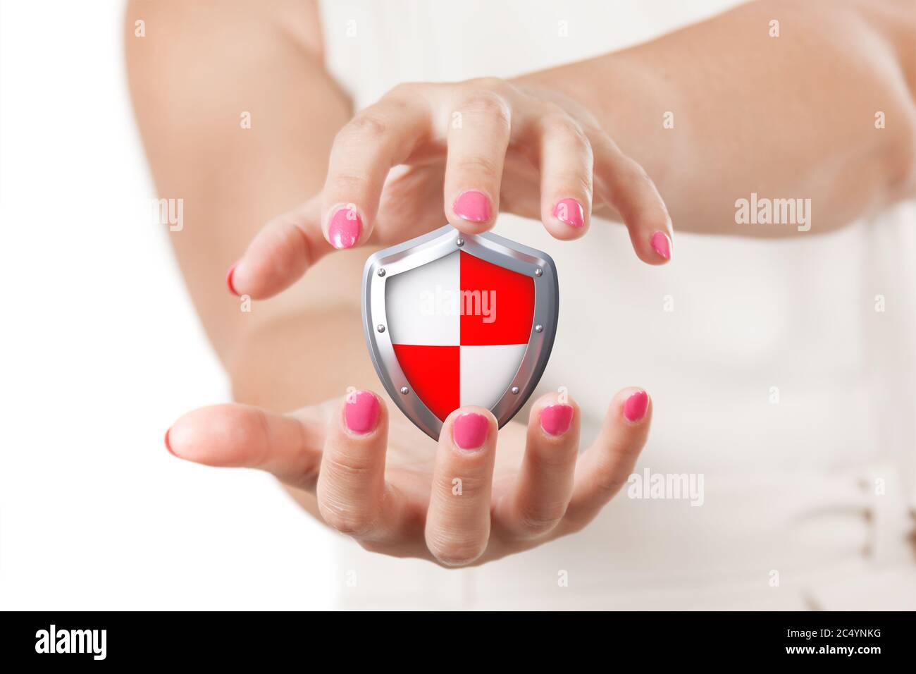 Concept sécurisé. Deux mains de femme tenant le bouclier de protection sur un fond blanc. Banque D'Images