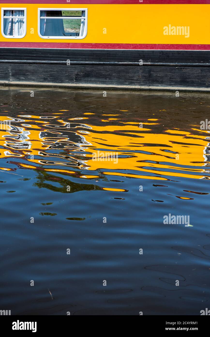 Barge jaune reflétée dans les eaux d'un canal en Angleterre, au Royaume-Uni Banque D'Images