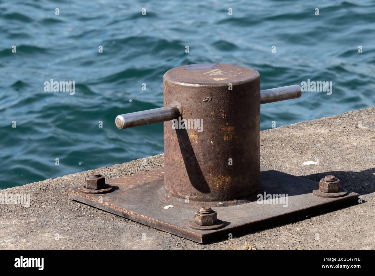 Un navire maritime rouillé amarre un cale ou un bollard sur un jetée au bord de l'eau Banque D'Images