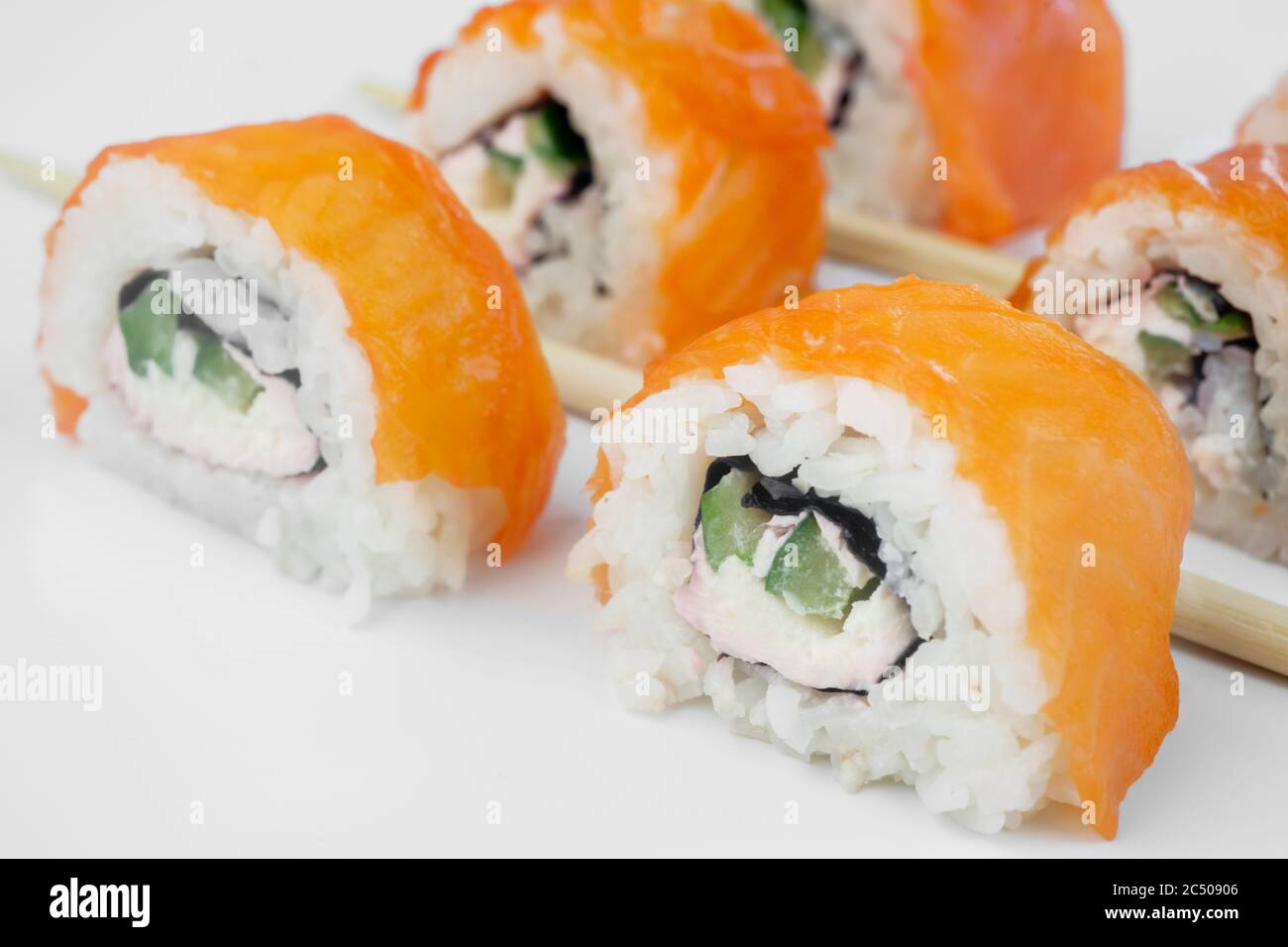 Les sushis roulent avec du saumon et reposent sur un tableau noir en pierre d'ardoise Banque D'Images