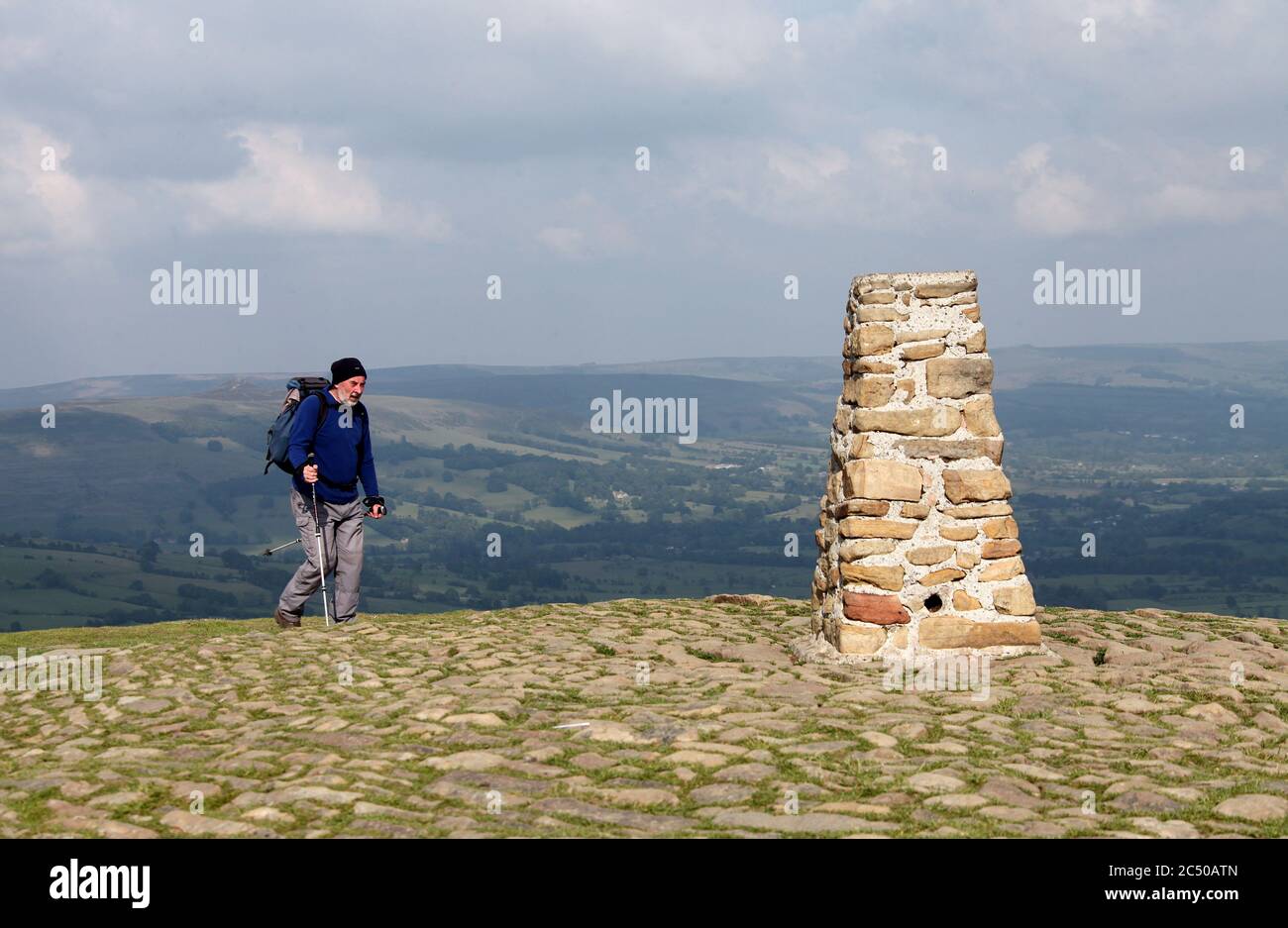 Randonneur atteignant le point de trig de pierre sur MAM Tor dans le parc national du district de Derbyshire Peak Banque D'Images