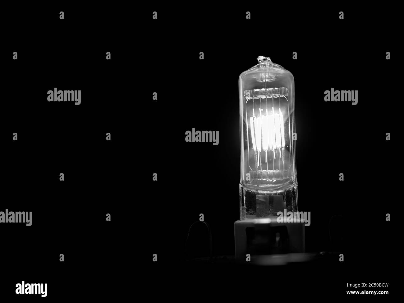 Filament de l'ampoule en feu. Ampoule électrique au tungstène sur fond noir Banque D'Images