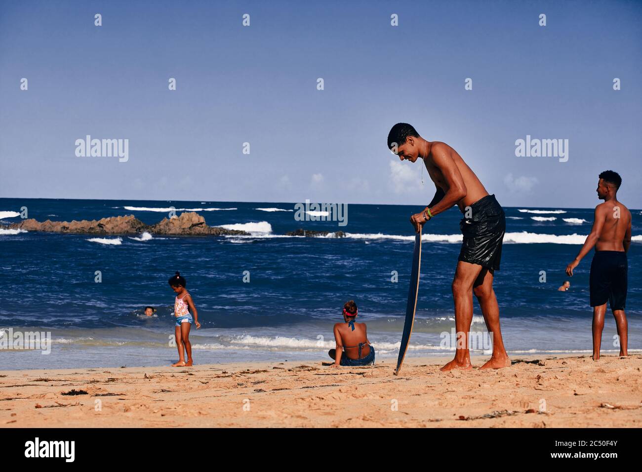 Jeune homme avec un skimboard sur la plage. Sports nautiques, océan Atlantique. République dominicaine. 29.12.2016. Banque D'Images