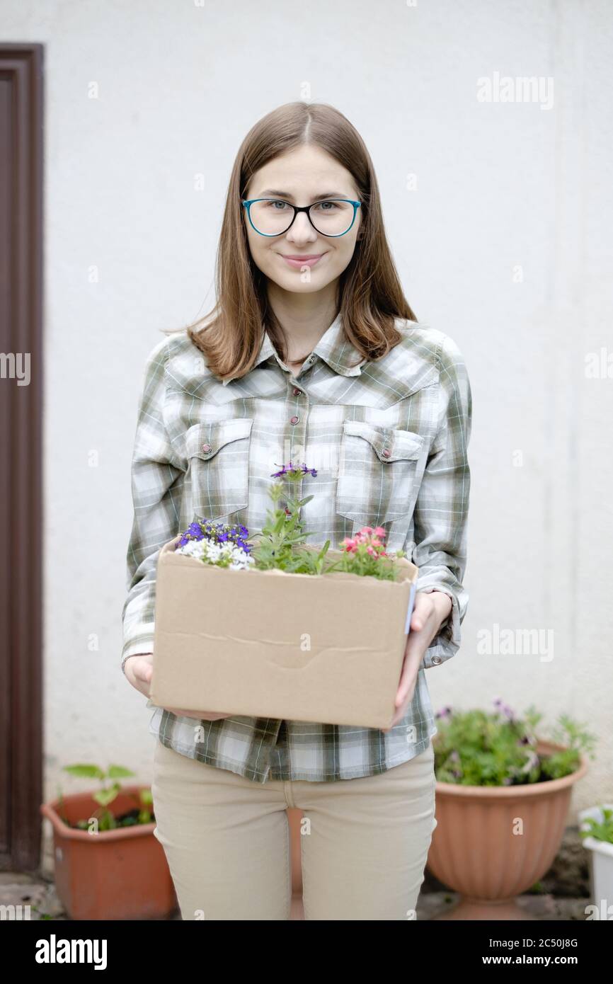 femme tenant une boîte de fleurs pour les planter un lit de fleurs Banque D'Images