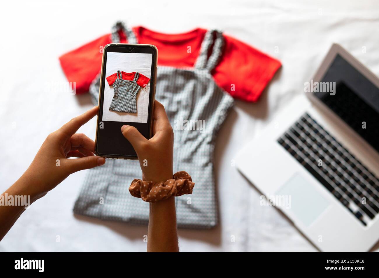 Femme prenant une photo d'un article de vêtements à vendre en ligne.  Concept de vente de vêtements en ligne. Vêtements d'occasion Photo Stock -  Alamy