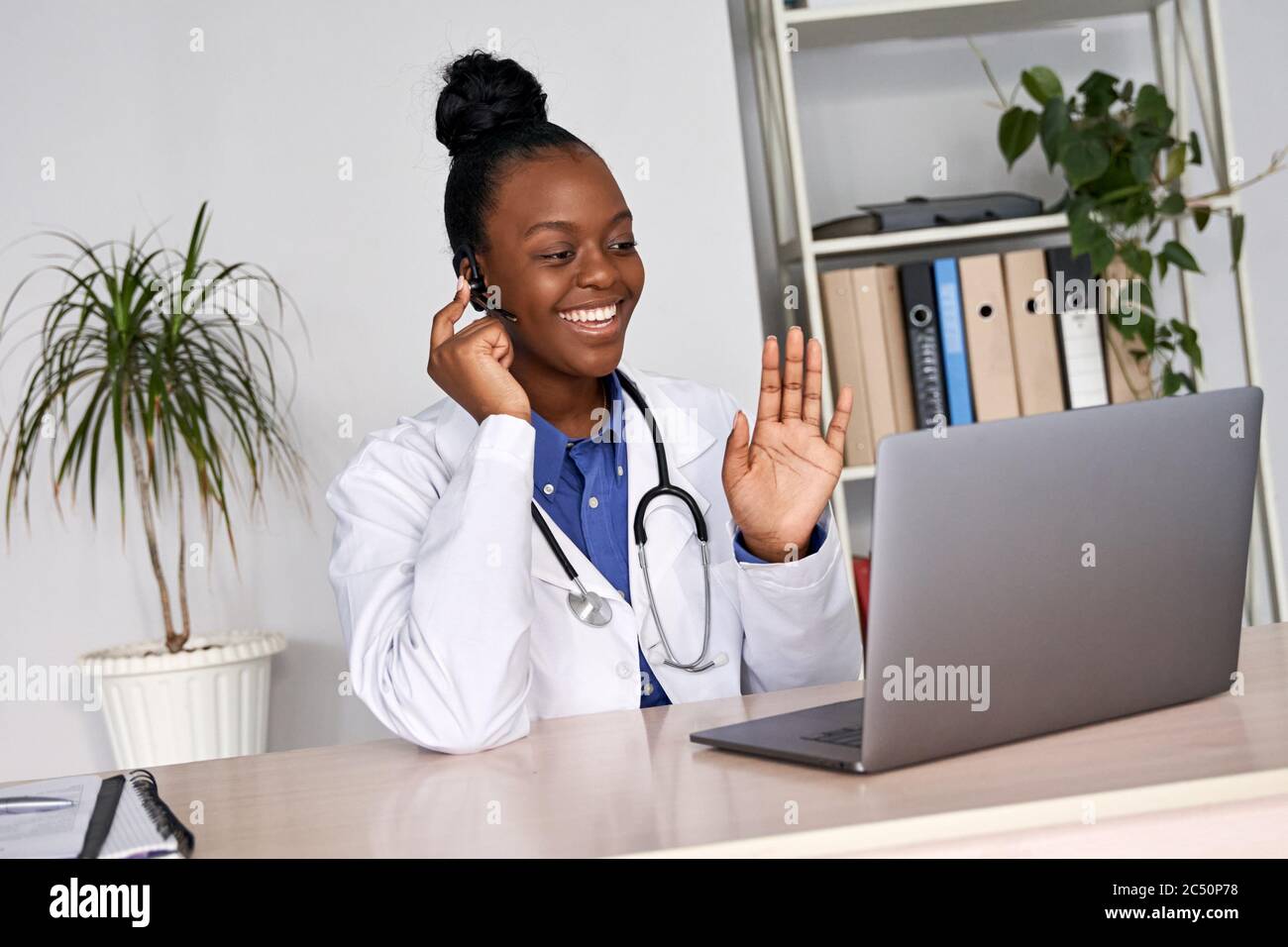 Une femme africaine médecin parle au patient par vidéoconférence en ligne avec webcam. Banque D'Images