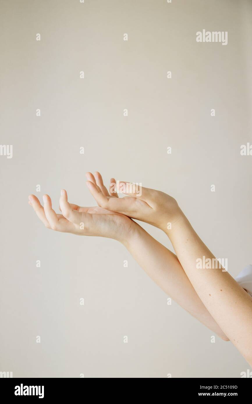 Les mains douces sont pliées ensemble et les paumes sont maintenues vers le haut. Il y a des grains de beauté sur les mains Banque D'Images