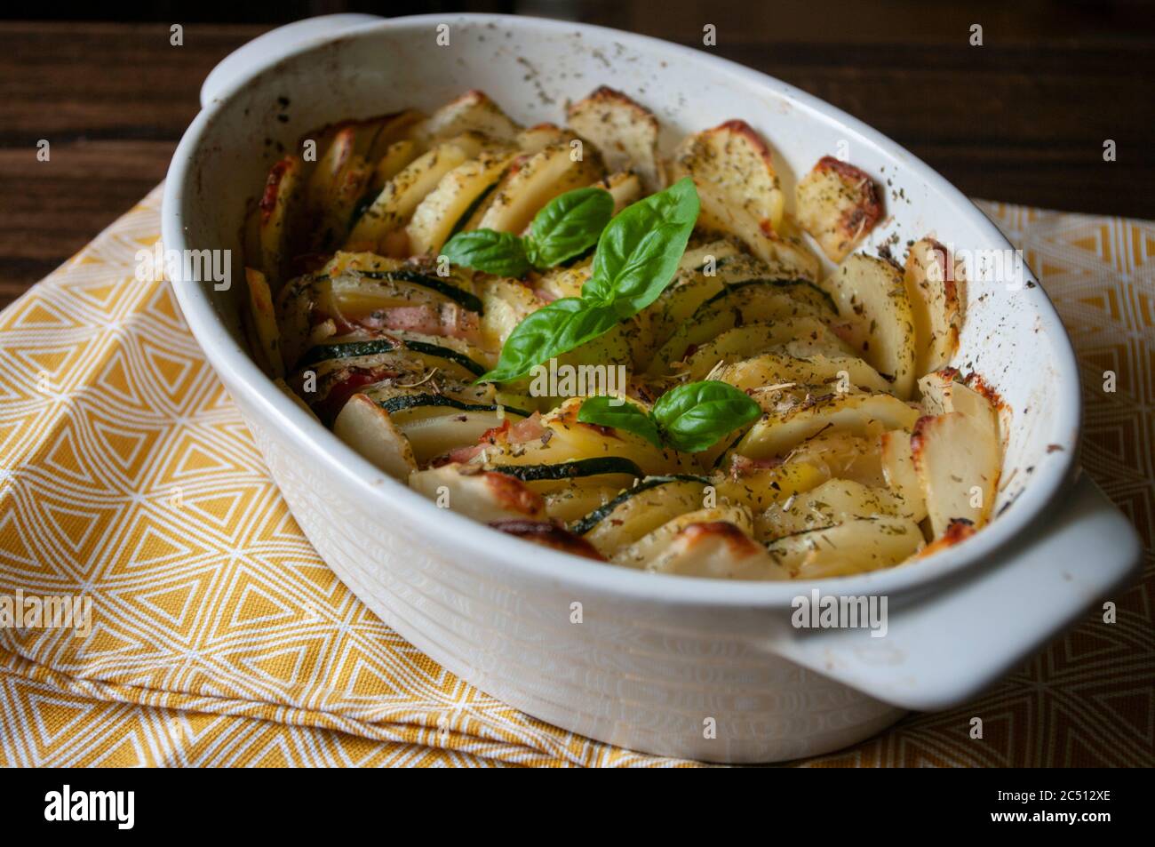 Recette de plat de cocotte. Gratin de pommes de terre copieux, bacon et  courgettes, fraîchement servis au four sur une table en bois. Gros plan  Photo Stock - Alamy