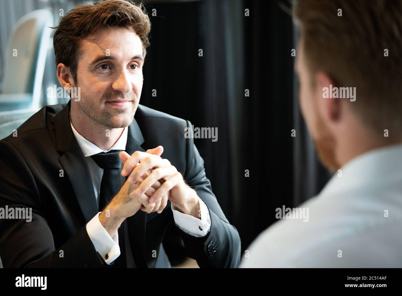 Businessman smiling réussie tout en discutant avec son partenaire au cours de réunion à Pause café Banque D'Images