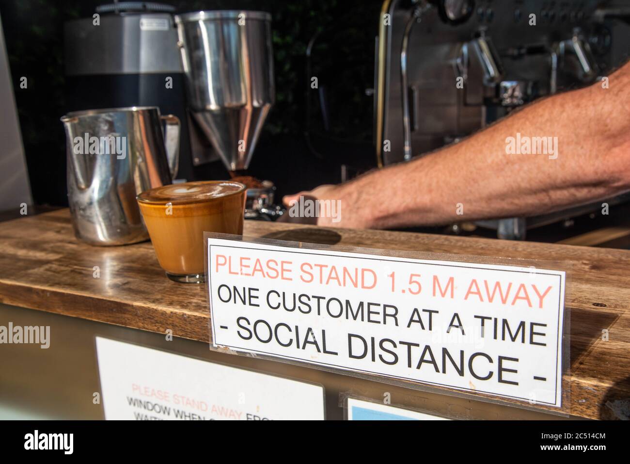 Brisbane, Australie. 30 juin 2020. Un barista sert un café près d'un panneau pour vous informer sur les distances sociales au milieu de la crise Covid-19.le Premier ministre du Queensland, Annastacia Palaszczuk, participe à une réunion du cabinet d'un État le mardi 30 juin pour annoncer une réouverture possible de la frontière et des recommandations sanitaires. (Photo de Flo Rols/Pacific Press) crédit: Agence de presse du Pacifique/Alamy Live News Banque D'Images