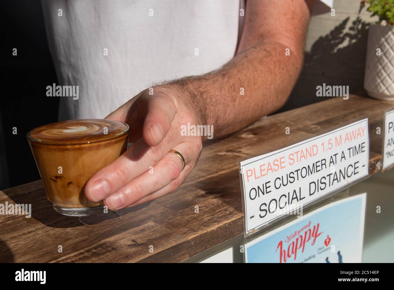 Brisbane, Australie. 30 juin 2020. Un barista sert un café près d'un panneau pour vous informer sur les distances sociales au milieu de la crise Covid-19.le Premier ministre du Queensland, Annastacia Palaszczuk, participe à une réunion du cabinet d'un État le mardi 30 juin pour annoncer une réouverture possible de la frontière et des recommandations sanitaires. (Photo de Flo Rols/Pacific Press) crédit: Agence de presse du Pacifique/Alamy Live News Banque D'Images